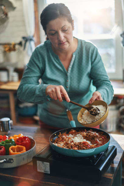 preparazione di peperoni ripieni con carne macinata in salsa di pomodoro - tomato sauce domestic kitchen meat cheese foto e immagini stock