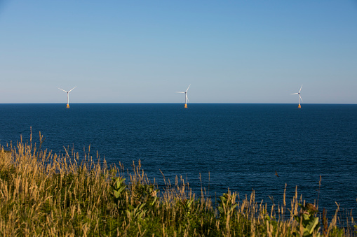 Wind turbines stand off the shores of Block Island, Rhode Island, USA.