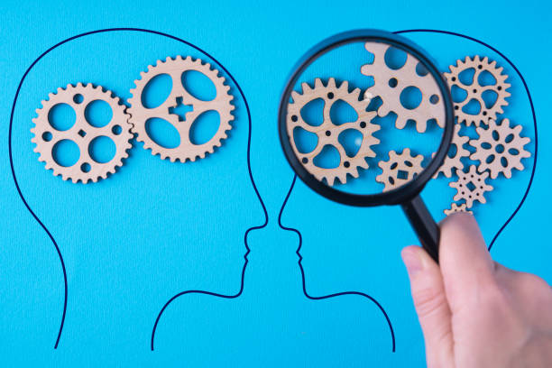 istock Human brain is made gear mechanism on blue background. The brain is viewed through a magnifying glass. Two different thought processes. 1302488282