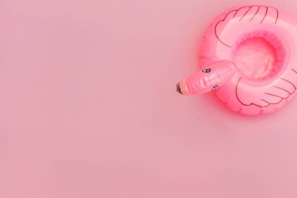 istock Summer beach composition. Simply minimal design with Inflatable flamingo isolated on pastel pink background. Pool float party, trendy celebrity fashion concept. Flat lay top view copy space 1302490316
