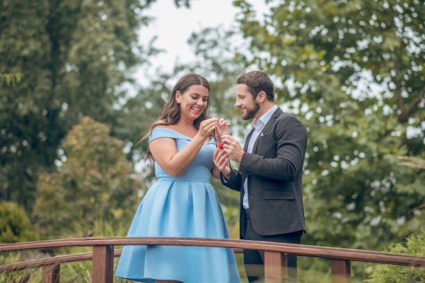 istock Happy man and woman accepting engagement ring 1302490393