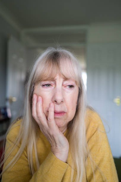 istock Depressed senior woman sitting alone at home 1302490700