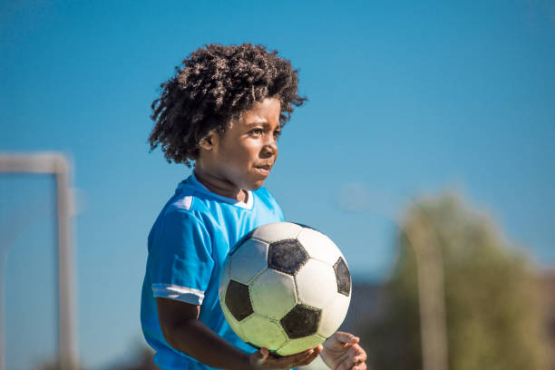 istock Beautiful young black boy training on the football pitch 1302491908