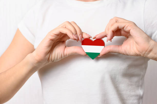 Love Hungary. A girl holds a heart in the form of a flag of Hungary on her chest. Hungarian concept of patriotism