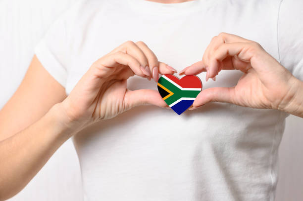 Love South Africa. The girl holds a heart in the form of the flag of South Africa on her chest. South African concept of patriotism