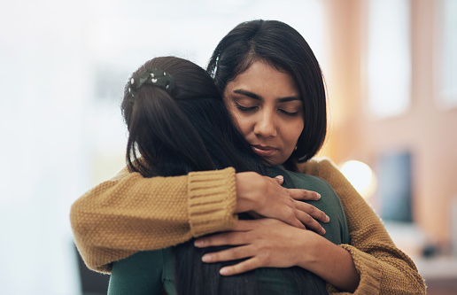 Cropped shot of two young women embracing each other at home