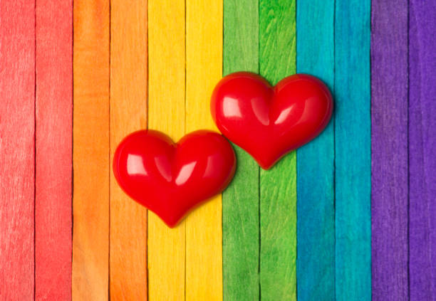 istock Close up photo of two red hears isolated on multicolored striped backdrop 1302499749