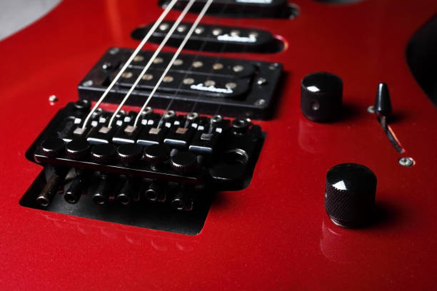istock Iron bridge for securing and tensioning the strings. Red electric guitar close up, selective focus. 1302499891