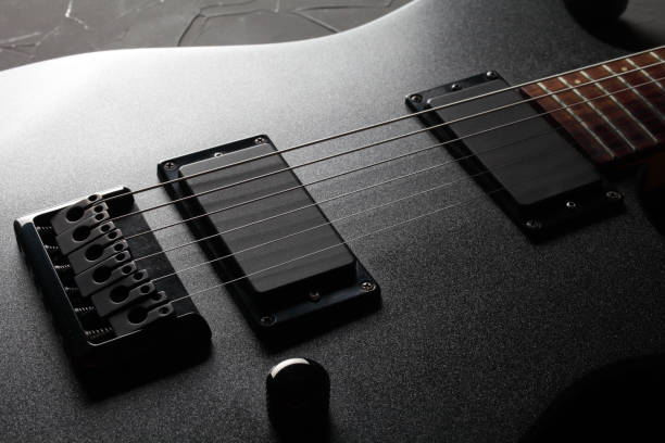 istock Black electric guitar on a black concrete background close-up. 1302500634
