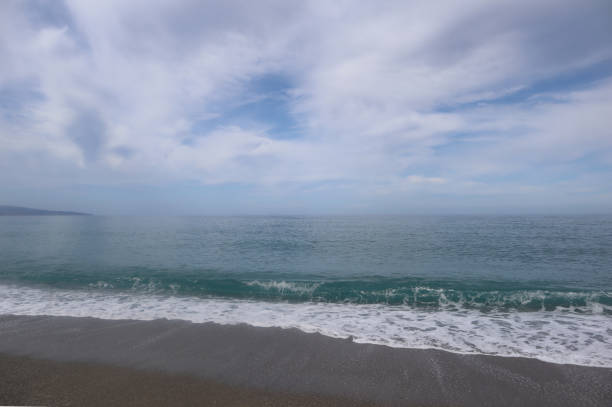 istock Blue sea with waves and sky with white clouds on an autumn day 1302501145