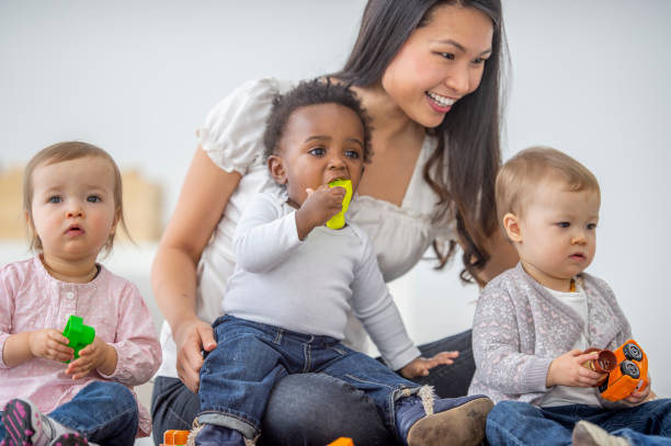 istock Asian female preschool teacher playing with her students 1302503248