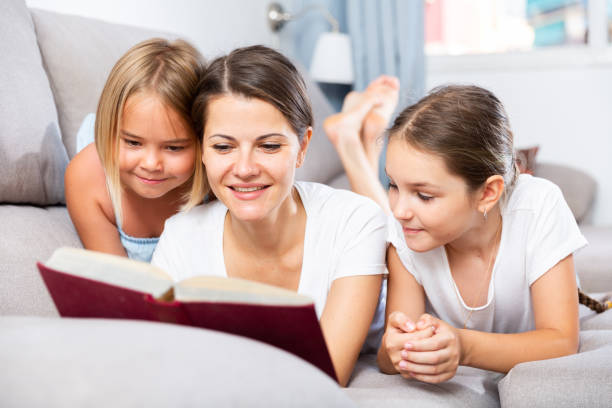 istock Mom reads tales for her daughters lying on sofa 1302503525
