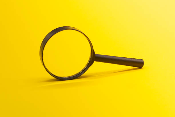 istock magnifying glass on yellow background. Search concept. 1302503893