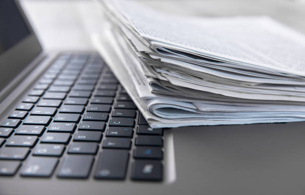 istock Newspapers and laptop 1302503899