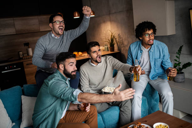 istock Friends watching sport on tv 1302504851