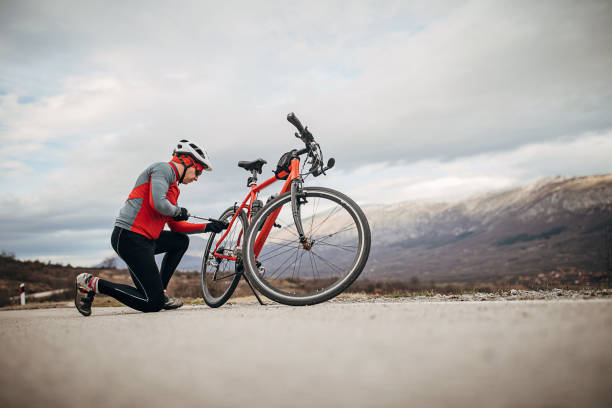 istock Professional cyclist man inflates bicycle wheel 1302506070