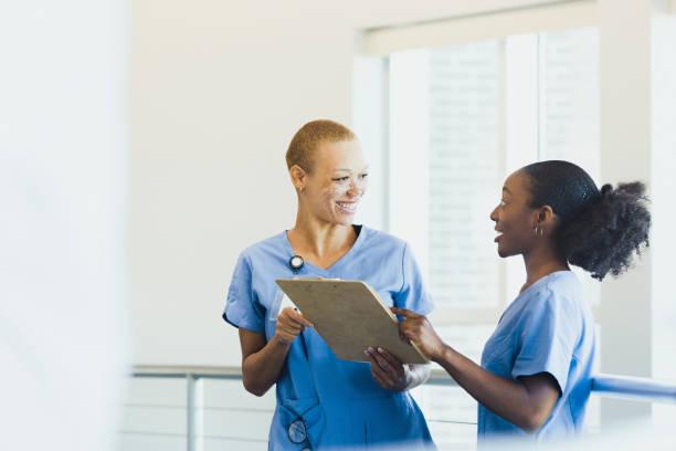 istock Female nursing student asks supervisor questions about patient chart 1302507134