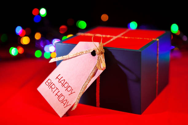 istock Gift box label with text - , red background with colorful lights from the back. 1302507191