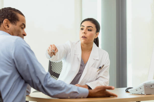 Female doctor discusses patient's arm pain A female doctor points to an area on a mature male patient's arm during a medical exam pain points stock pictures, royalty-free photos & images
