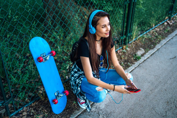 istock Smiling girl with skateboard 1302508944