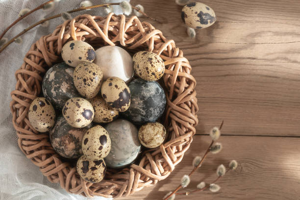 istock Easter composition - Easter eggs painted with natural dyes in a wicker nest on a wooden table, copyspace 1302509646