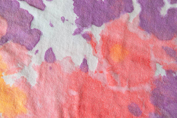 Pastel tie dye, a handmade pattern on a cotton t-shirt. Close-up, top view. DIY concept, handicrafts, original everyday clothes, fabric dyeing techniques. Flat lay, horizontal. Abstract background.