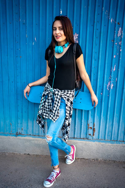 istock Young woman standing with skateboard 1302509791