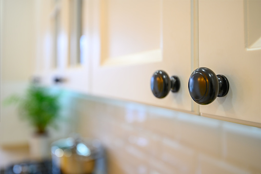 closeup to knobs at kitchen cabinet doors, selective focus