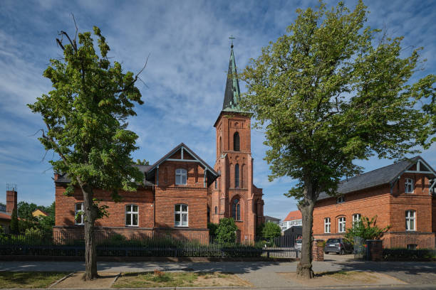 Listed catholic church "Herz Jesu" ("Sacred Heart") in Neuruppin with clergy house (left) and school house (right) stock photo
