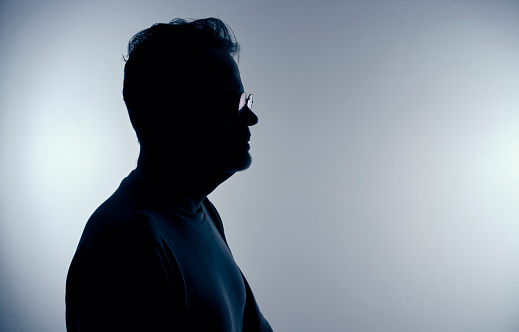 A silhouette portrait of a man in profile.