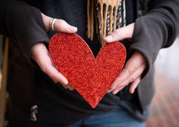 istock Red Paper Heart Being Held in a Woman's Hands 1302517158