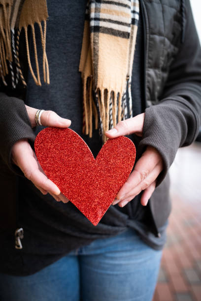 istock Red Paper Heart Being Held in a Woman's Hands 1302517725