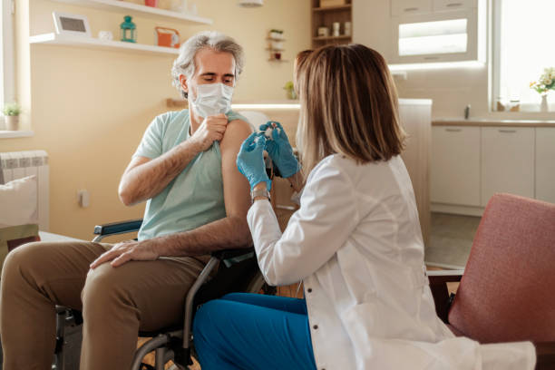 istock General Practitioner Vaccinating Disabled Person at His Home 1302517794