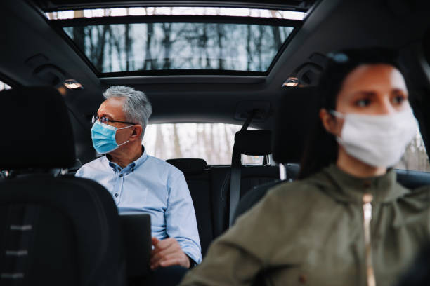 istock Older man finishing work while riding in the carshare during pandemic 1302518739