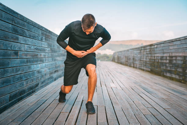 남자 주자 는 훈련 하는 동안 위 측면 경련 또는 스티치. 그의 옆구리통증을 앓고 있는 운동선수. 조깅이나 달리기 후 측면 통증. - pain stitch side view jogging 뉴스 사진 이미지