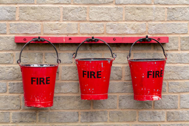 벽에 걸려 있는 빨간 양동이 세 개 - fire bucket 뉴스 사진 이미지