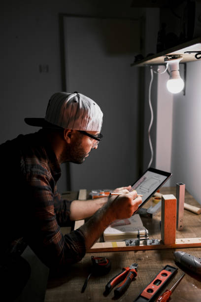 Teenager working on tablet for DIY project at home stock photo