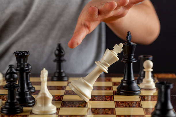 istock player resigns at a chess game by tipping over his king 1302530050