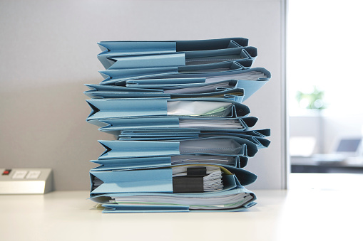 Stack of file folders with documents on a desk in the office