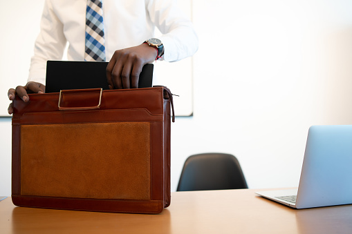 Businessman putting everything in his briefcase at the end of the work day at office. Business concept.