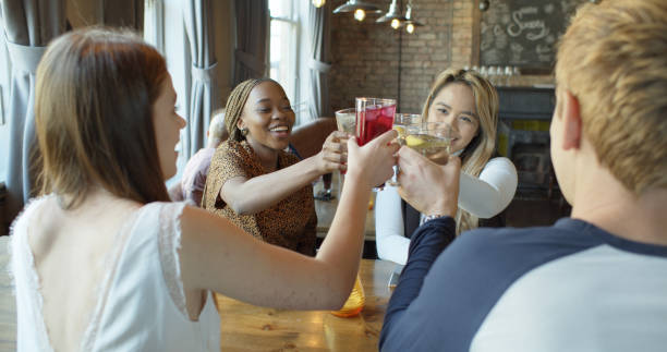 istock Three Women and a Man Making a Toast in a Pub 1302531548