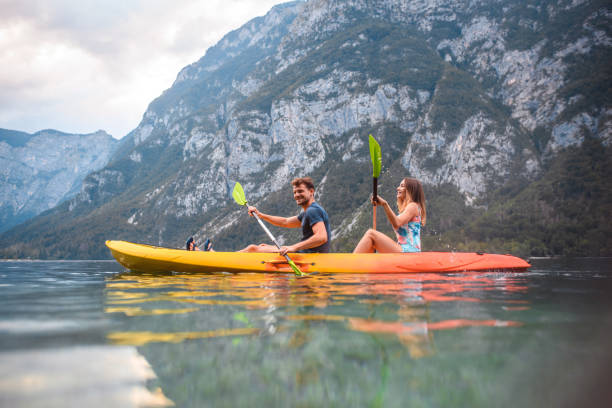 mid adult couple kayaking in triglav national park - lake bohinj imagens e fotografias de stock