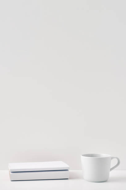 istock The mug stands on a stack of books on a white background. Natural and eco-friendly materials. Copy space, mock up 1302532522