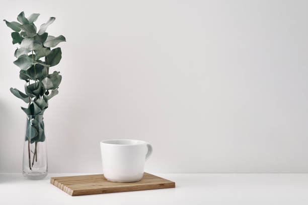 istock A mug, wooden board and a transparent vase with eucalyptus branches. Eco-friendly materials in interior decor, minimalism. Copy space, mock up. 1302532525