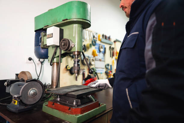 istock Young male manual worker working on a drill machine in a small production of endless rubber bands and belts 1302532691