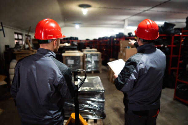 istock Male warehouse workers sorting finished rubber mats for gym in warehouse 1302532728