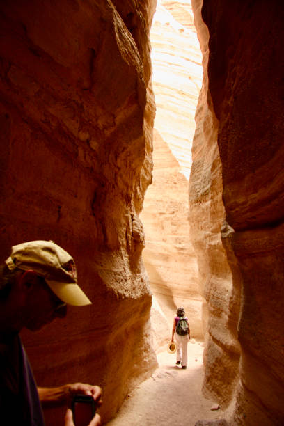 Hiking at Kasha-Katuwe National Monument Photo of a man and a woman in a slot canyon at Kasha-Katuwe National Monument in New Mexico, USA. kasha katuwe tent rocks stock pictures, royalty-free photos & images