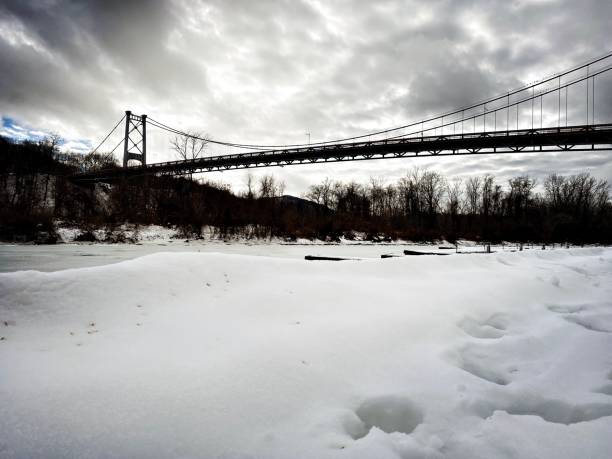 istock Suspension Bridge over a Frozen River 1302534986