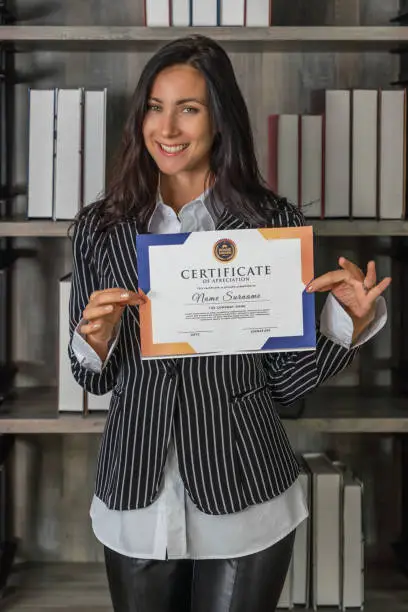 Photo of business portrait of caucasian business woman posing with certificate of appreciation recieved from business performace competition award winning