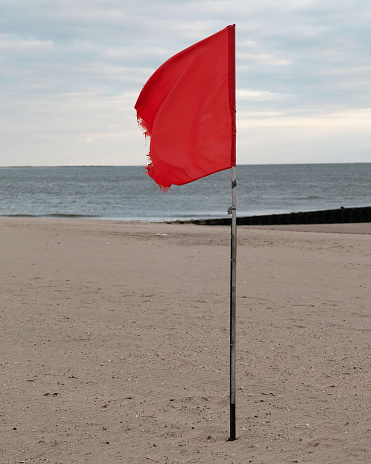 Red flag on the beach at Coney Island in New York.
